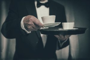 Butler Serving Mug from Tray of White Cups